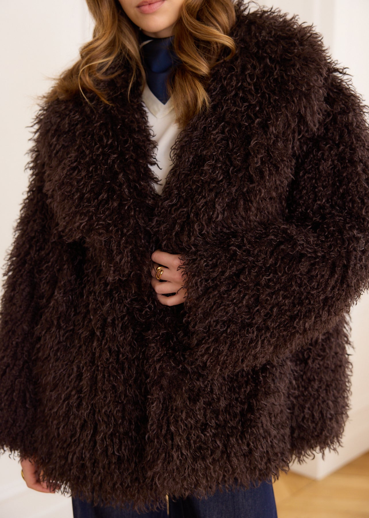 Brown faux fur coat with curly hair, long sleeves, and a round