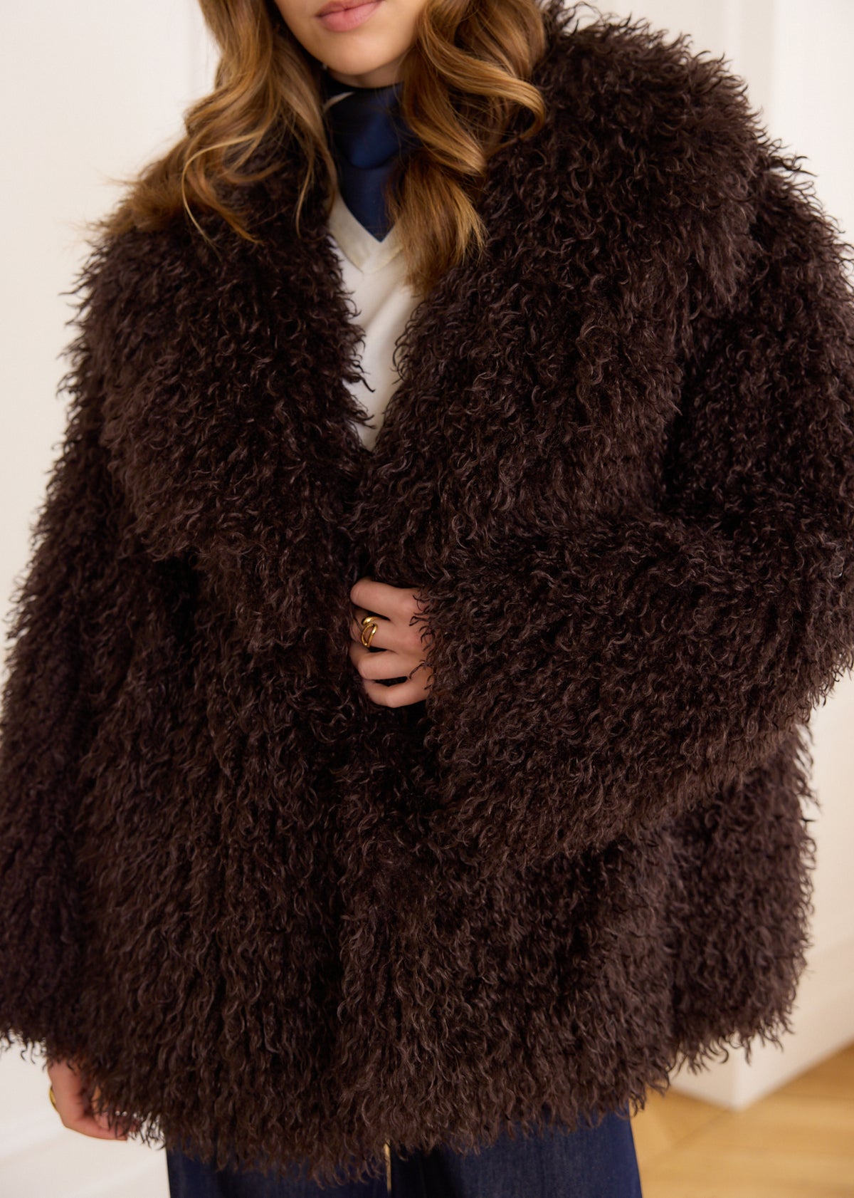 Brown faux fur coat with curly hair, long sleeves, and a round 
