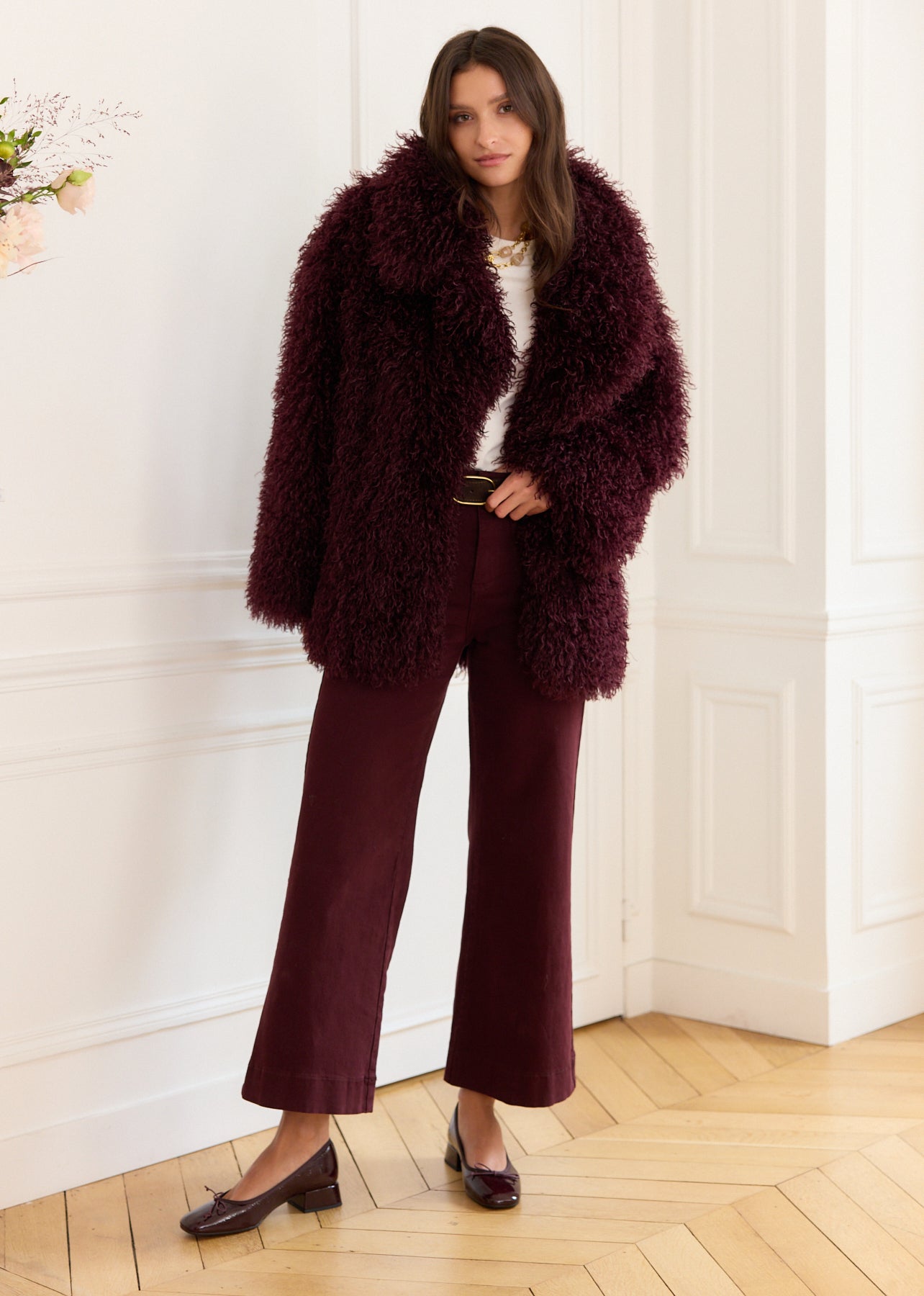 Burgundy faux fur coat with curly hair, long sleeves, and a round